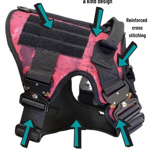 May include: A pink and black dog harness with adjustable straps, heavy-duty metal buckles, and a comfortable mesh material. The harness features hook and loop panels and reinforced cross stitching.