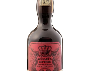 May include: A dark brown glass bottle of Bogart's Bitters with a gold cap. The main label is red with a black crown graphic and text reading Bogart's Bitters Manufactured by The Bitter Truth Germany. A cream-coloured secondary label is below.