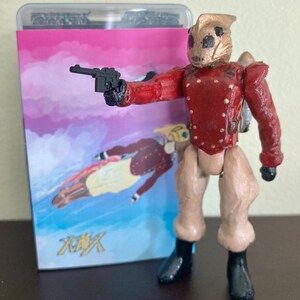May include: A hand-painted action figure of a robot wearing a red and gold uniform, holding a black gun. The figure is standing in front of a pink and blue background with the Japanese word "炎" written in black.