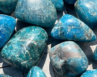 Puede incluir: Una colección de piedras de apatita azul pulidas. Las piedras son lisas y pulidas, con una variedad de tonos de azul.