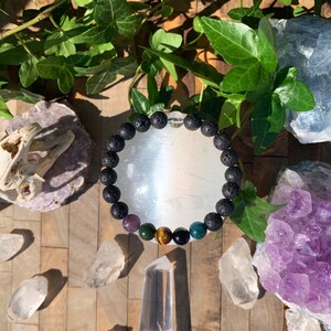 Op de afbeelding: Een armband van zwarte lavasteen met amethist, groene aventurijn, tijgeroog en zwarte onyx kralen.