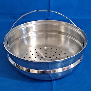 Puede incluir: Una cesta de vapor de acero inoxidable con una base perforada y un asa curva. La cesta tiene un acabado pulido y una banda decorativa alrededor del centro. El vaporizador está diseñado para cocinar verduras y otros alimentos.