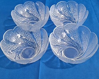 May include: Set of four clear glass bowls with a decorative etched design. The bowls have a scalloped edge and are perfect for serving snacks or desserts.