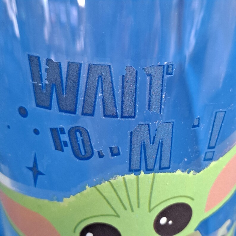 Peut inclure: Gobelet bleu avec le texte "WAIT FOR M!" et un dessin d'un personnage extraterrestre vert. Le gobelet a un fond bleu avec un motif d'&eacute;toiles et de points.