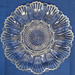 Peut inclure: Un plat de service en verre transparent avec un bord festonné et un motif central en étoile. Le plat comporte huit sections, parfait pour servir des amuse-gueules ou des en-cas.
