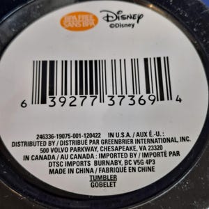 Puede incluir: Primer plano de una etiqueta blanca con un c&oacute;digo de barras y el logotipo de Disney. La etiqueta tambi&eacute;n incluye el texto "BPA FREE SANS BPA" y las palabras "TUMBLER GOBELET".