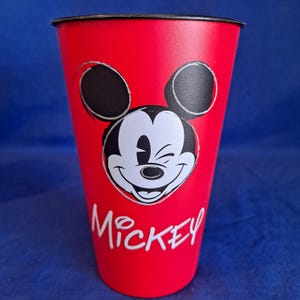 Puede incluir: Una taza de cer&aacute;mica blanca con un asa negra y el texto "But First, Coffee" en negro, en negrita. La taza est&aacute; sobre una superficie blanca.