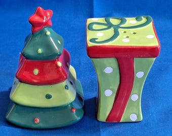 Juego de salero y pimentero con forma de árbol de Navidad, envuelto para regalo con cintas navideñas.