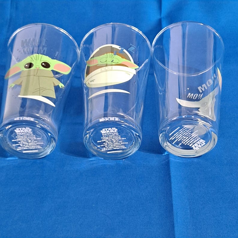 Peut inclure: Trois verres transparents avec des images de Grogu de The Mandalorian. Un verre a Grogu avec le texte "WANT TO M". Un autre verre a Grogu dans un pod. Le troisi&egrave;me verre a le texte "MOM" et Grogu. Chaque verre a du texte Star Wars en bas.
