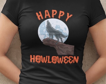 May include: A black short-sleeved t-shirt featuring a graphic of a wolf howling at a full moon on a rocky cliff. The text above reads HAPPY and the text below reads HOWLOWEEN in orange, dripping-style lettering with pumpkin faces in the letters.