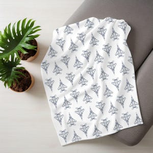 May include: White fleece blanket with a repeating pattern of blue fighter jets.