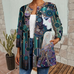 以下が含まれることがあります： 女性の横顔をモチーフにした、ティール、紫、金色の芸術的なデザインのオープンフロントジャケット。幾何学模様が特徴で、白いトップスとブルージーンズの上に着用されています。ジャケットの長さは約100cmです。