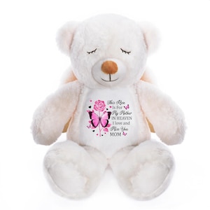 May include: A white plush teddy bear with a printed design. The design features a pink rose, a butterfly, and the text "This Rose Is For My Mother In Heaven I love and Miss You MOM". The bear has closed eyes.