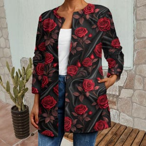 Può includere: Una giacca nera aperta con un audace motivo a rose rosse. La giacca ha maniche lunghe e tasche. Le rose sono dettagliate con steli e foglie verdi, creando un contrasto con lo sfondo nero. La giacca è lunga fino al ginocchio.