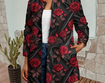 May include: A long-sleeved open-front jacket in black featuring a repeating pattern of deep red roses with dark green leaves and stems. The jacket has a round neckline, a straight hem, and two side pockets, worn over a white top and blue jeans.