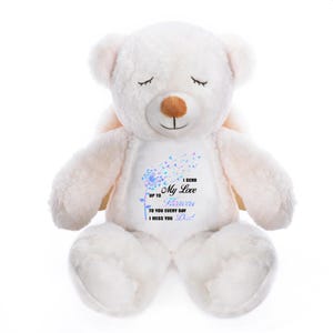 May include: A white plush teddy bear with closed eyes and small wings. The bear has a brown nose and a design on its chest with the text "I send my love up to heaven to you every day I miss you Dad."
