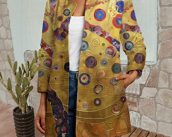 Puede incluir: Una chaqueta de manga larga abierta por delante con una base dorada y un patrón repetitivo de motivos circulares multicolores en tonos azules, rojos y verdes. La prenda se lleva sobre una camiseta blanca lisa y unos vaqueros azules.
