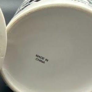 Pu&ograve; includere: Tazza in ceramica bianca con illustrazioni in bianco e nero. Il fondo della tazza riporta la scritta "Made in China."