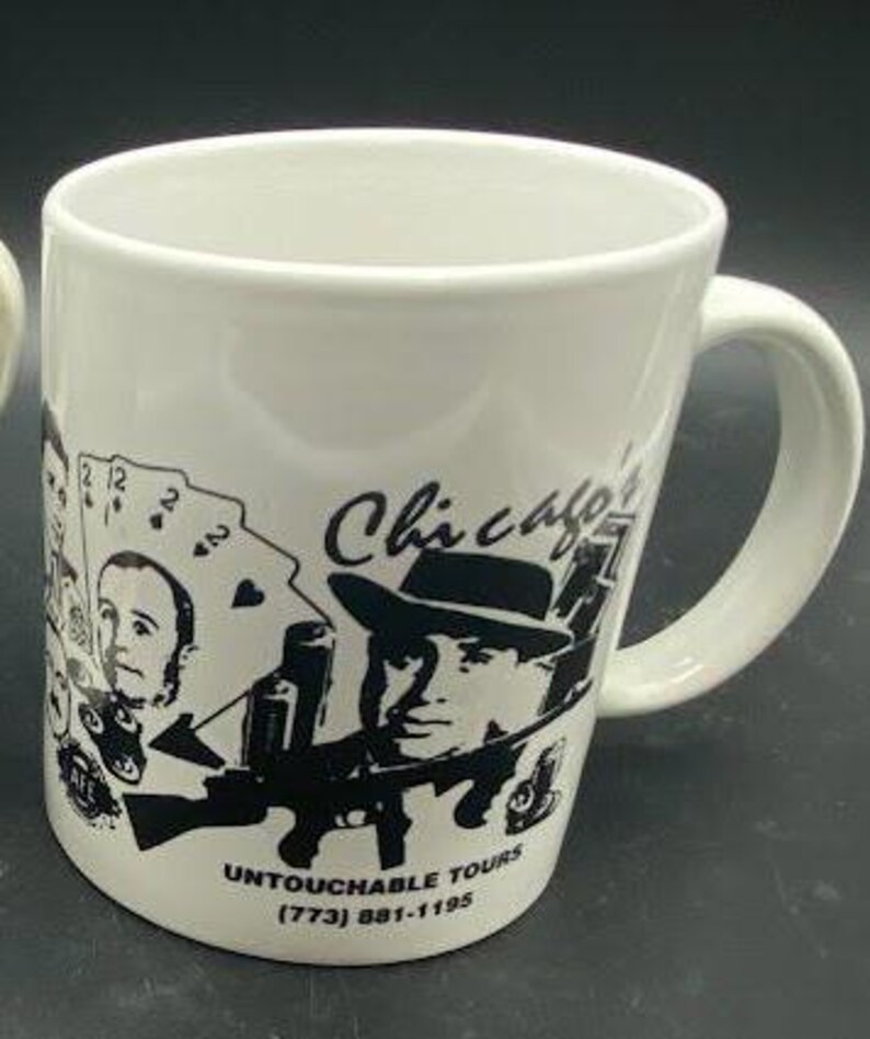 Pu&ograve; includere: Tazza in ceramica bianca con un'illustrazione in bianco e nero di un uomo con un fedora e il testo "Chicago" e "Untouchable Tours (773) 881-1195".