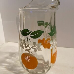 Vintage glass juice pitcher with oranges and leaves
