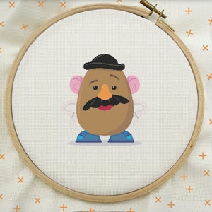 May include: A brown potato character with a black hat, blue shoes, and a moustache. The character has pink ears and a brown face with a red mouth.