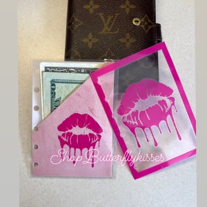 May include: Two pink plastic card holders with a pink dripping lip design. The text "Shop Butterflykisses" is printed on one of the holders.