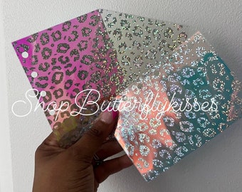 May include: Three sheets of iridescent holographic vinyl with a leopard print pattern. The vinyl is pink, white, and teal.