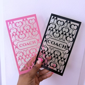 Könnte beinhalten: Zwei rechteckige Aufkleber mit einem sich wiederholenden Coach-Logo-Muster. Ein Aufkleber ist rosa mit weißen Aussparungen, der andere ist schwarz mit weißen Aussparungen. Beide zeigen das Wort COACH in einem zentralen Rahmen.