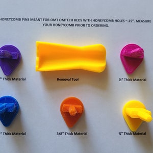 May include: Assortment of colorful plastic honeycomb pins in various sizes, including 1/8 inch, 1/4 inch, 3/8 inch, and 1/2 inch thick. A yellow plastic removal tool is also included. The text "HONEYCOMB PINS MEANT FOR OMT OMTECH BEDS WITH HONEYCOMB HOLES ~.25". MEASURE YOUR HONEYCOMB PRIOR TO ORDERING." is visible in the image.