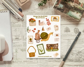 May include: A sheet of stickers featuring illustrations of snail mail, flowers, and a snail carrying a stack of packages. The stickers are designed in a vintage style with a muted color palette of browns, greens, and yellows. The text on the sheet reads "Stamps the Snail Mail by L.A. Florals".