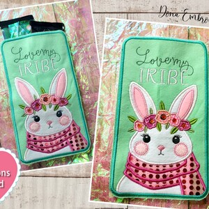 May include: A green felt applique with a white bunny wearing a pink and white polka dot scarf and a pink flower crown. The text "Love my Tribe" is embroidered in white on the applique.