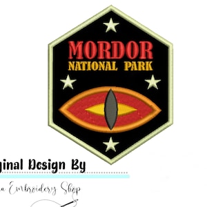 May include: A black hexagonal patch with a white border. The patch features a red eye with a yellow pupil and the text "Mordor National Park" in yellow letters.
