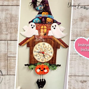 Puede incluir: Un reloj de temática de Halloween con un sombrero de bruja, fantasmas y calabazas. La esfera del reloj está rodeada por un marco de madera con un diseño tallado. El reloj está colgado en una pared blanca con el texto "Dona Embroidery Shop" e "Instructions Included" visible.
