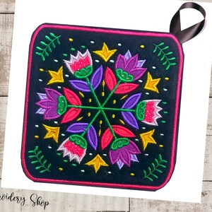 May include: A black square pot holder with a colorful floral design embroidered on it. The design features pink, purple, green, and yellow flowers with a black background. The pot holder has a black ribbon loop for hanging.