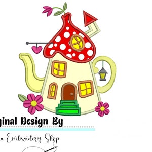 Può includere: Una casa a forma di teiera gialla e fantasiosa con un tetto a fungo rosso e bianco a pois. La casa ha finestre, una porta e un portico verde. Ci sono fiori rosa su entrambi i lati della casa. Il testo "Original Design By Donna Embroidery Shop" è in fondo all'immagine.
