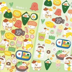 Könnte beinhalten: Zwei Bögen bunter Aufkleber mit japanischen Speisen und Katzenfiguren. Die Aufkleber zeigen Sushi, Ramen und andere Gerichte. Der Text "Oishii" ist auf den Aufklebern zu sehen. Die Aufkleber befinden sich auf einem hellgrünen Hintergrund.