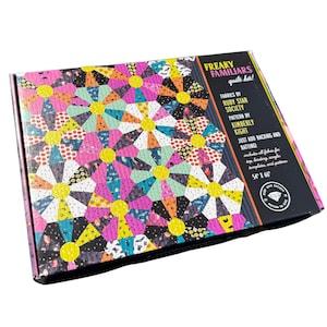 May include: A rectangular quilt kit box titled Freaky Familiars Quilt Kit by Ruby Star Society and Kimberly Kight. The box features a colourful floral-patterned design with yellow centres and measures 137 cm by 168 cm as printed on the box.