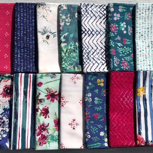 Puede incluir: Una colección de 18 muestras de tela con varios patrones y colores, incluyendo diseños florales, geométricos y abstractos. Las muestras están dispuestas en dos filas de nueve, con una mezcla de colores oscuros y claros.