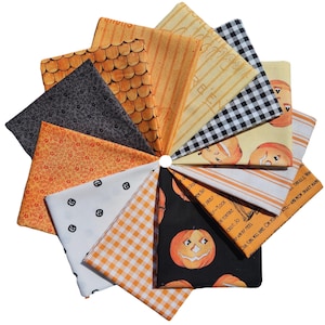 Puede incluir: Una colección de cuadrados de tela dispuestos en abanico circular, con varios estampados que incluyen caras de calabaza naranjas, cuadros vichy en blanco y negro, pequeños motivos florales negros, rayas naranjas y diseños con texto sobre fondos blancos y negros.