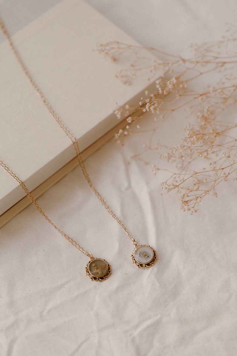 This real pressed flower necklace is perfect for adding a touch of cottage charm to your look! Featuring dried flowers embedded in resin, it makes for a stunning accent to any ensemble.