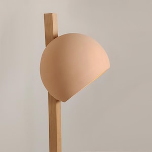 Add intrigue to your space with Naaya Stuck, a unique clay shade pierced by a wooden support