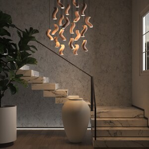 A stunning ceramic chandelier suspended elegantly in a two-story staircase, casting a luxurious warm glow, creating an inviting and opulent atmosphere