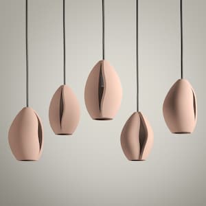 May include: Five modern pendant lights with a soft pink finish. Each light has an organic, oval shape with a vertical slit revealing the interior. The lights hang from black cords, creating a minimalist aesthetic.