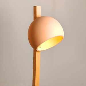 Tall Naaya Stuck lamp offers focused lighting with an artistic clay and wood construction.