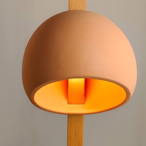 Stuck floor lamp features a wooden pierce-through design for modern, statement-worthy interiors.