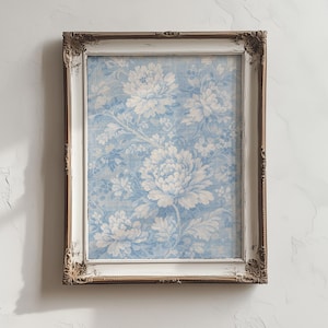 May include: A rectangular framed artwork featuring a floral pattern in shades of blue and white. The frame is white with gold accents on the corners. The artwork is mounted on a white wall.