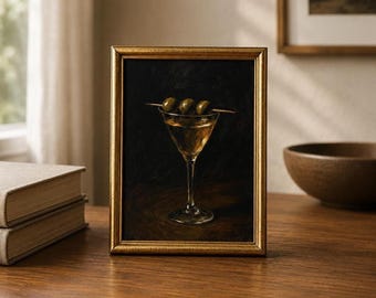 Peut inclure: Une peinture à l'huile encadrée représentant un verre à martini rempli d'un liquide doré et garni de trois olives vertes sur un pic en bois, sur un fond sombre et nuancé dans un cadre fin de couleur or métallique.