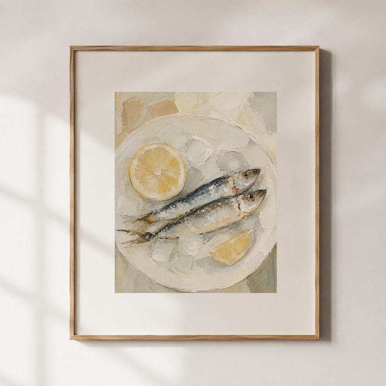 May include: A framed painting of two sardines on a white plate with lemon slices and ice. The artwork has a neutral color palette with shades of white, gray, and yellow. The painting is in a wooden frame.