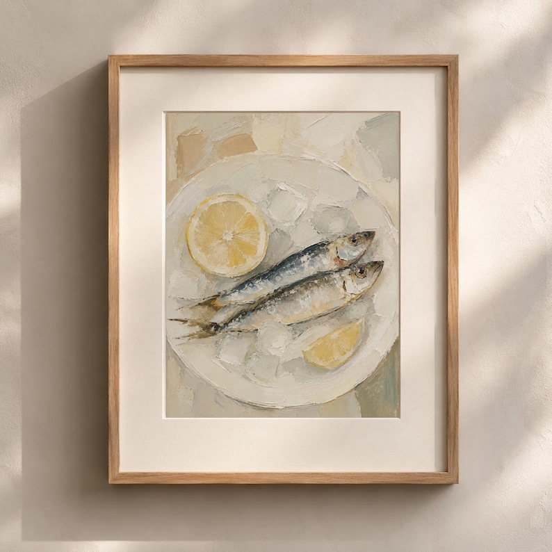 May include: A framed painting of two sardines on a white plate with a lemon slice. The artwork has a textured, oil-paint style, with a neutral color palette of white, yellow, and blue. The frame is a light brown color.