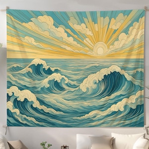 May include: A large wall tapestry depicting an ocean scene with stylized waves in shades of blue and white. The sun is setting, with yellow rays and clouds in the sky. The tapestry is hung on a white wall, above a white sofa.